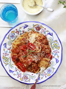 A ceramic Italian pasta dish filled with baked spaghetti squash noodles with tomato sauce.