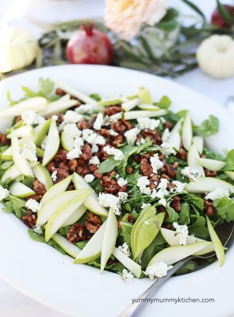 A big beautiful arugula salad with pear slices, candied walnuts, and goat cheese.