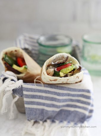 Two vegetarian or vegan gyros with flatbread and grilled vegetables.