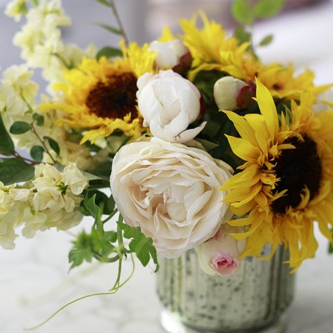 A beautiful DIY flower arrangement with sunflowers and garden roses.