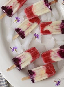 Red, white, and blue berry pina colada popsicles that are perfect for 4th of July.