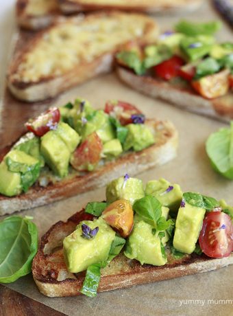 Beautiful and delicious avocado bruschetta with cubed avocado, fresh tomatoes, basil, and white balsamic.