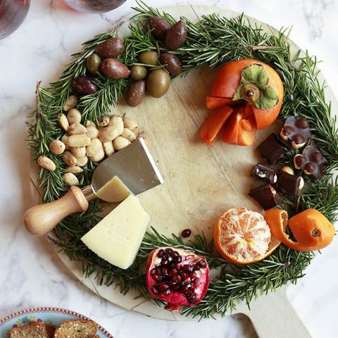 Beautiful wreath cheese board with marcona almonds, chocolate, citrus, pomegranate.