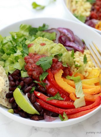 Vegetarian burrito bowl with peppers, black beans, salsa, guacamole, and quinoa.