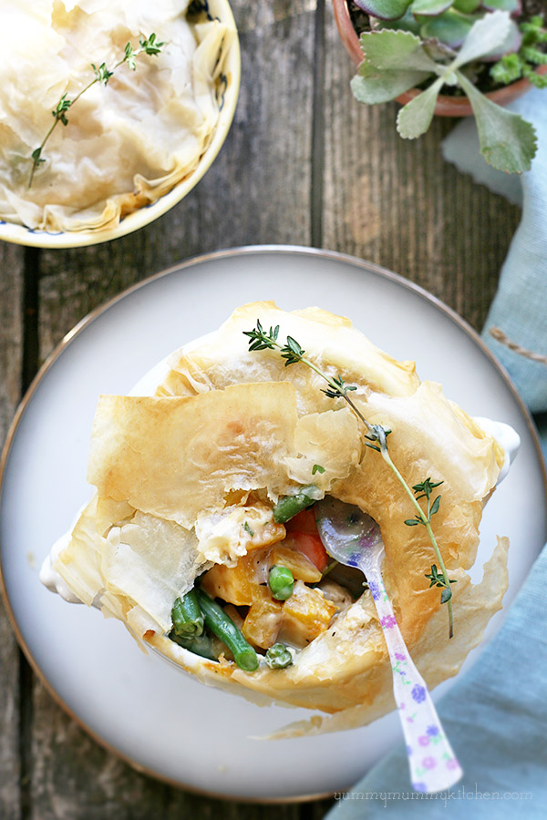 Mini pot pie topped with phyllo dough and filled with colorful vegetables like peas, green beans, and butternut squash. 