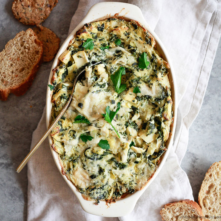 A casserole dish filled with vegan baked spinach artichoke dip. 