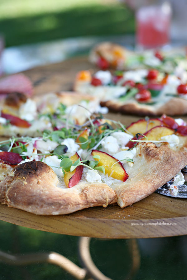 A close-up of a homemade no sauce sauceless pizza topped with nectarines and goat cheese. 