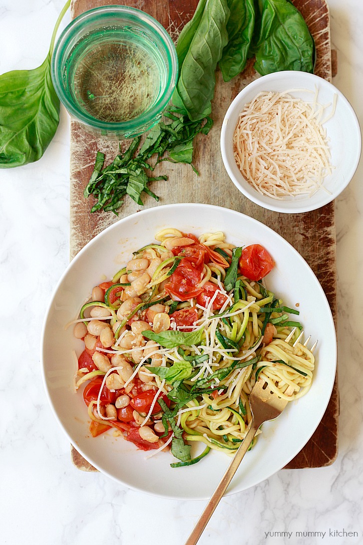Beautiful bowl of zucchini noodles with roasted cherry tomatoes, garlic, and white beans. 