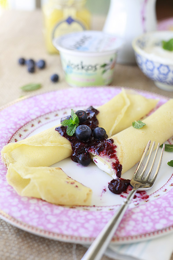 Beautiful plate of crepes filled with creamy lemon filling and topped with fresh blueberry sauce. 