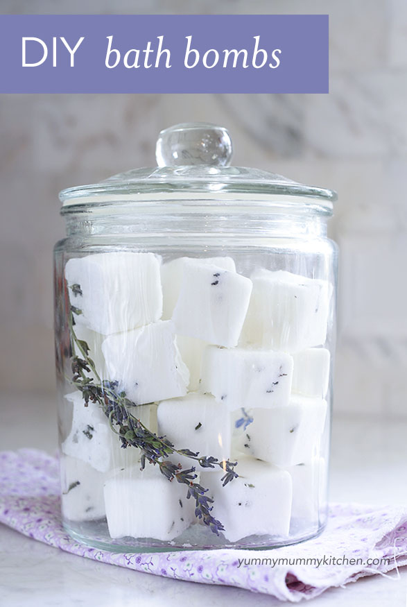 A clear glass canister filled with homemade lavender bath bombs. 