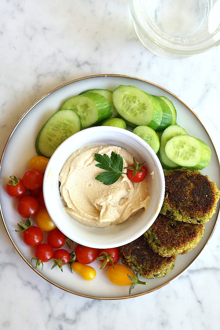 Vegan falafel served with cucumber, tomatoes, and hummus. 