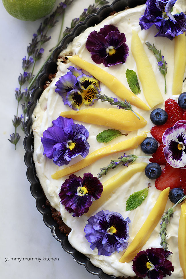 A beautiful breakfast fruit tart topped with edible flowers and fruit. 