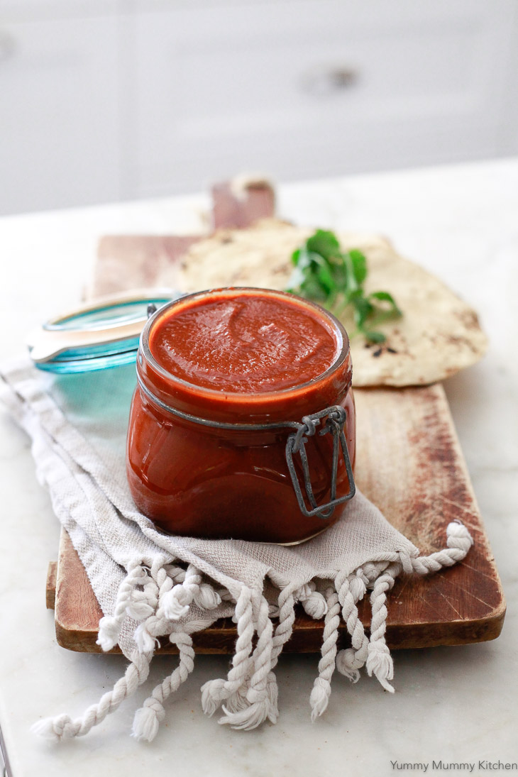 A glass jar of homemade enchilada sauce. 
