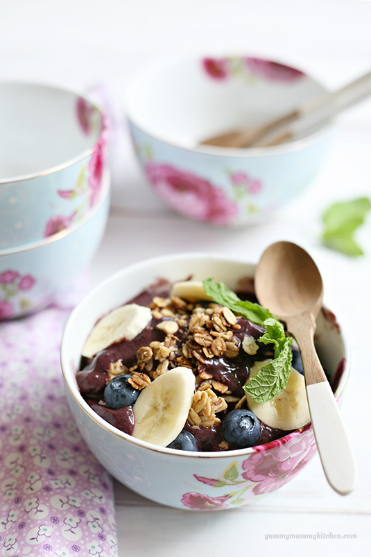 Beautiful acai breakfast bowl topped with berries, granola, and bananas. 