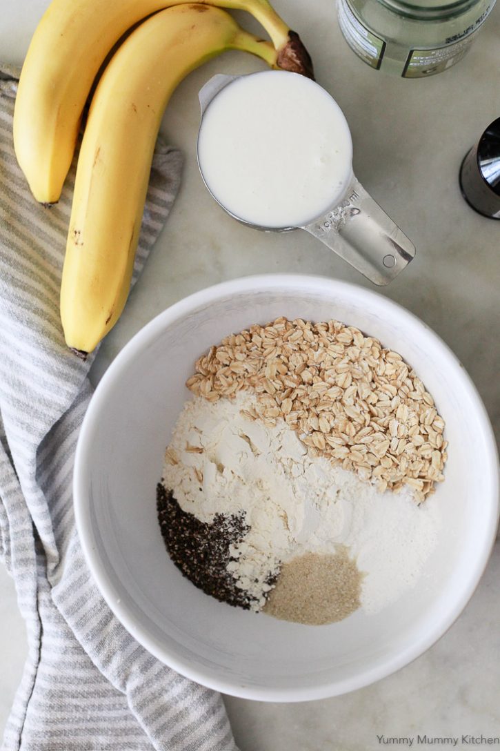  A white bowl is filled with flour, oats, chia seeds, and raw sugar for vegan banana pancakes. 