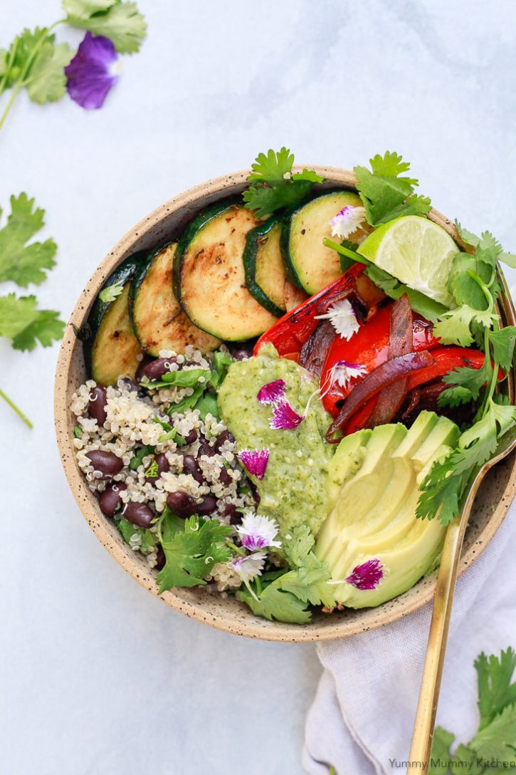 A beautiful vegan burrito bowl with quinoa, black beans, vegetables, avocado, and homemade roasted tomatillo salsa verde. 