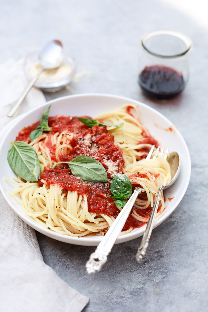 Healthy vegan crockpot spaghetti sauce over a bowl of spaghetti. 