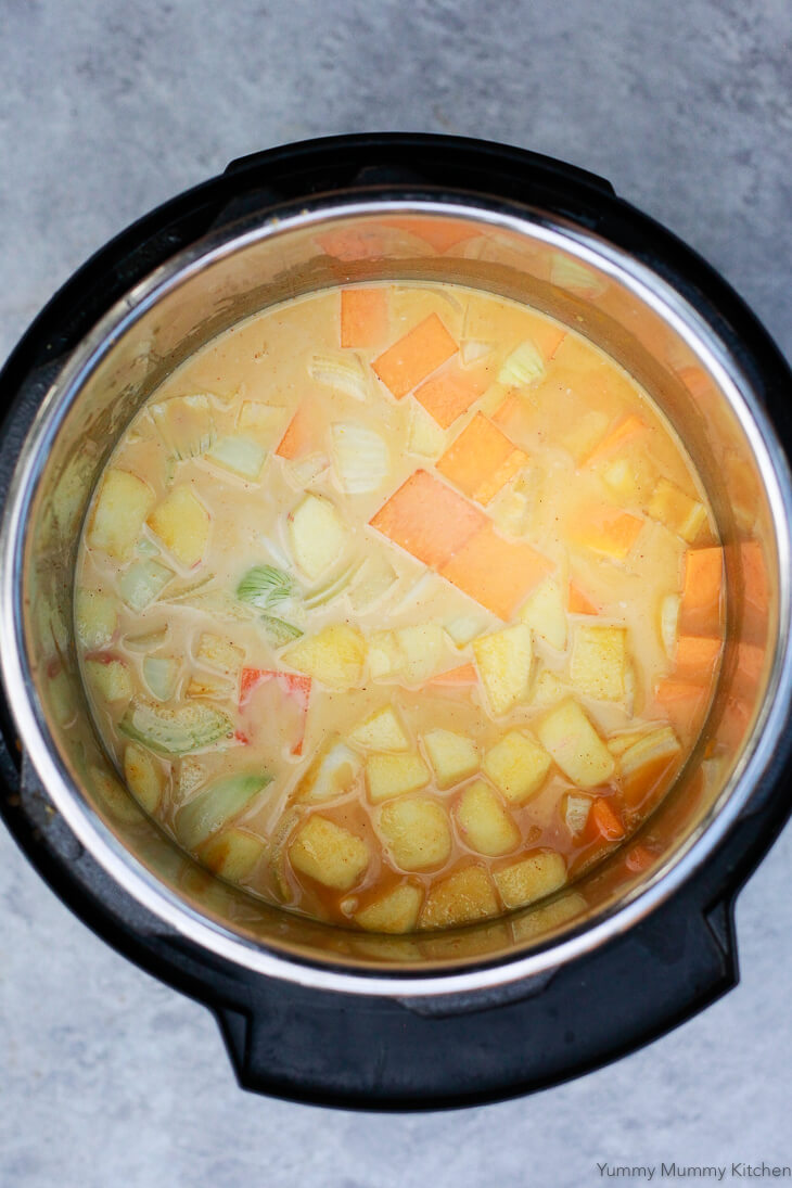 Vegetable broth and coconut milk are added to pumpkin, butternut squash, onion, apple and curry spices to make soup. 