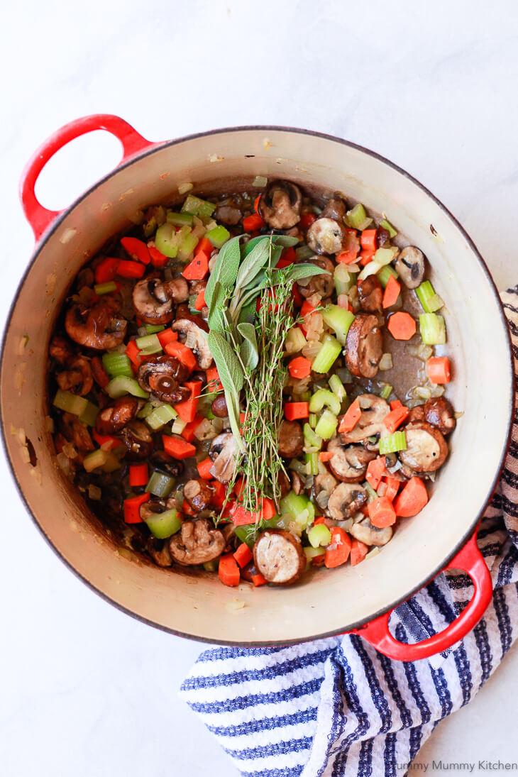 Sauteed carrots, celery, onion, and mushrooms in a pot with fresh sage and thyme. 