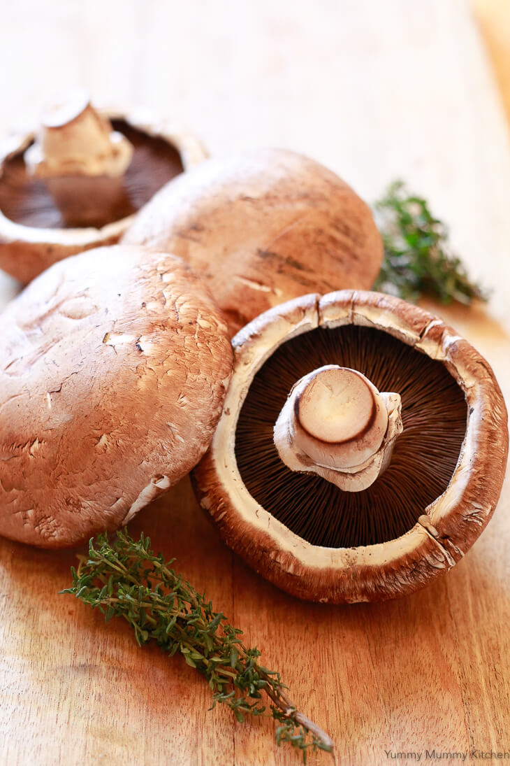 Portobello mushrooms on a cutting board to make vegetarian mushroom Wellington. 