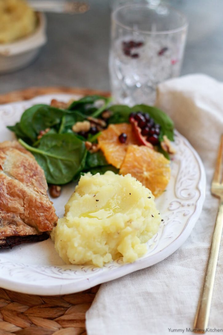 A vegan Thanksgiving or Christmas dinner plate with vegan mashed potatoes, Wellington, and salad. 