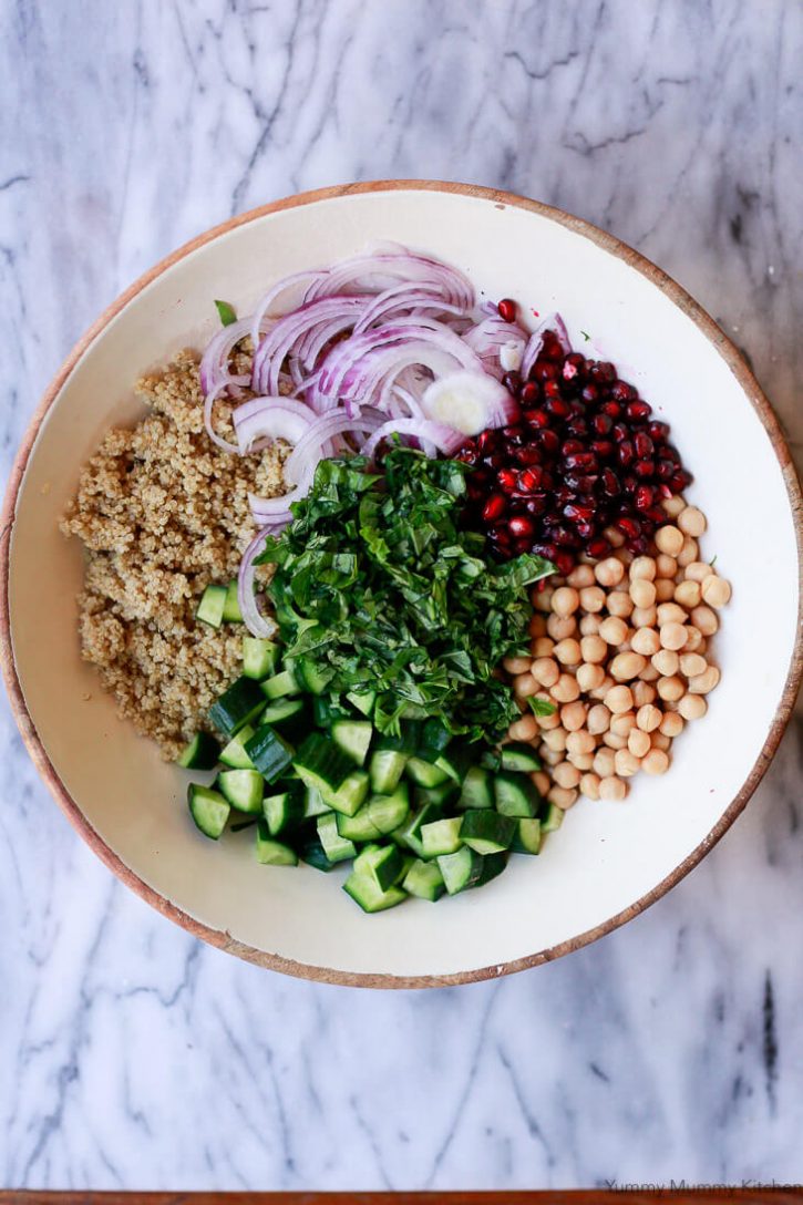 A beautiful salad with chickpeas, quinoa, herbs, cucumber, onion, and pomegranate. 