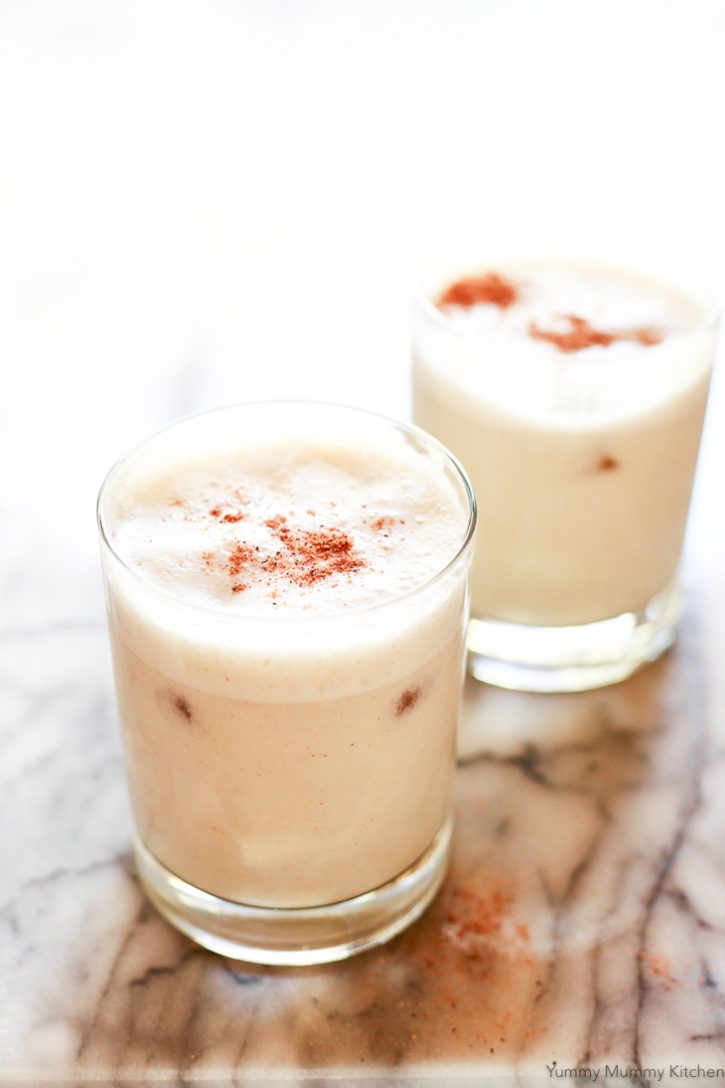 Glasses of cold homemade healthy vegan eggnog topped with nutmeg. 