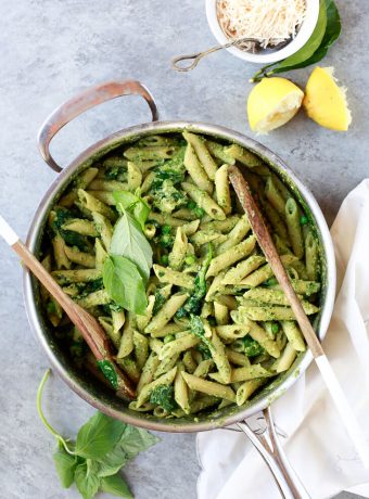 A pot filled with bright green pea and basil vegan pesto pasta.