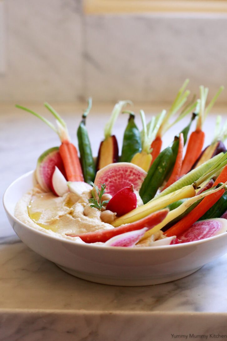 A beautiful bowl of hummus with colorful vegetables. 