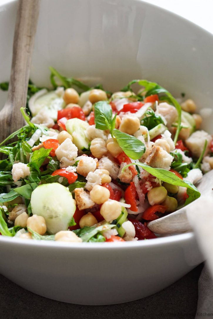 A bowl of panzanella salad with chickpeas and arugula. This photo was taken in Tuscany while making panzanella bread and tomato salad. 