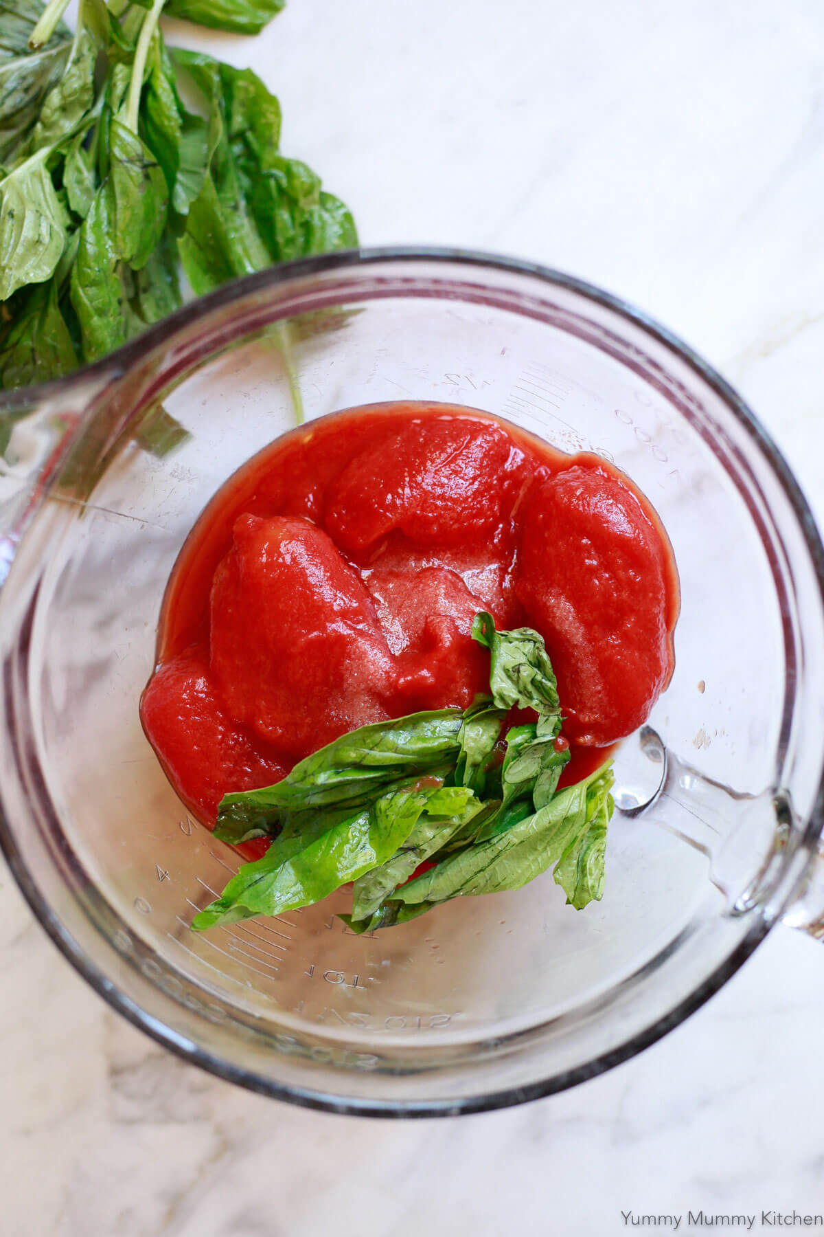 San Marzano canned tomatoes in a bowl with fresh basil. 