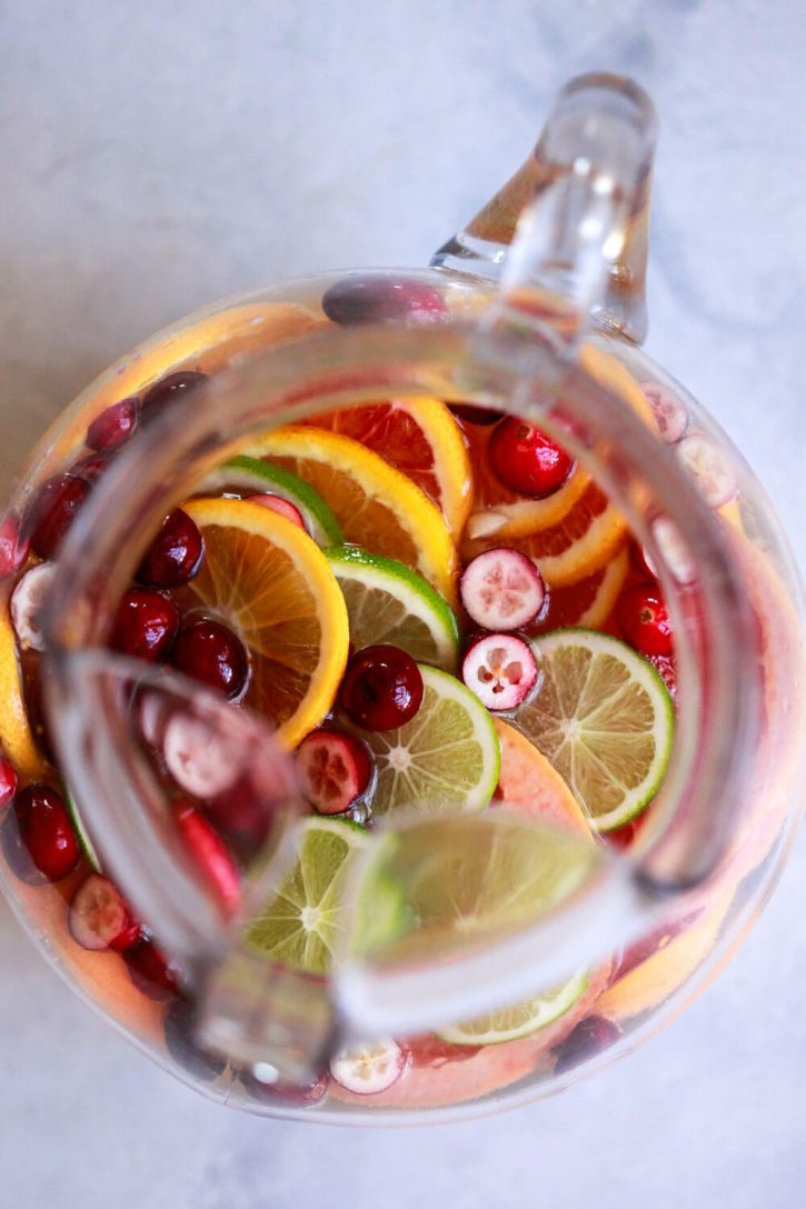 A pitcher of colorful white sangria with cranberries and citrus. This is the best white sangria recipe for a crowd. 