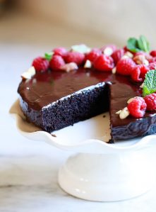 A beautiful vegan chocolate cake with ganache and raspberries.