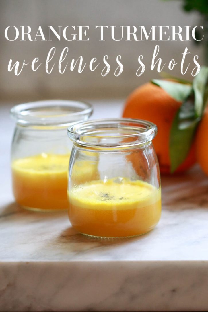 Two homemade orange turmeric shots on a kitchen countertop. How to make turmeric wellness shots at home. 