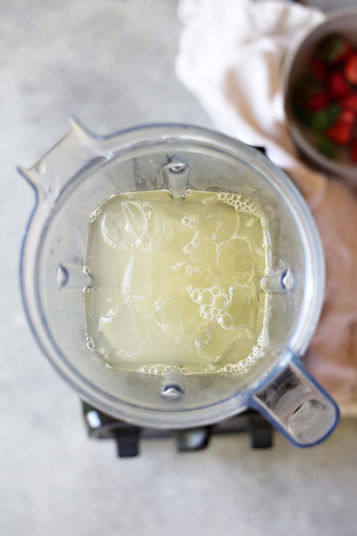 Blended Lemonade A Vitamix blender is filled with lemon juice, water, sugar, and ice to make blended lemonade.