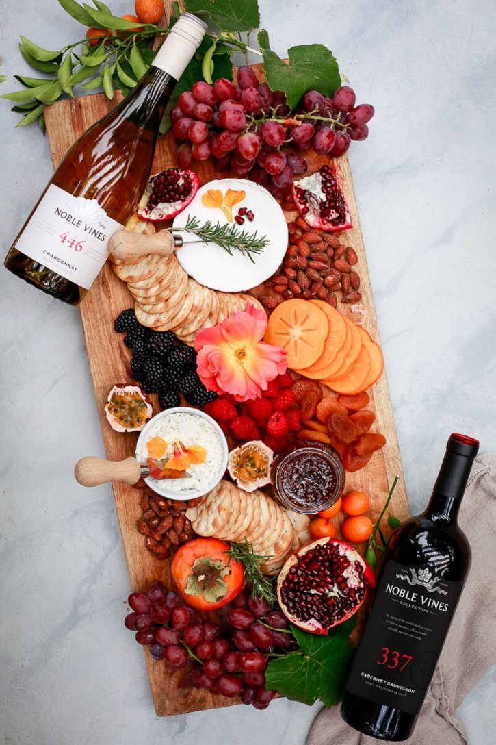 A beautiful charcuterie board with fruit, nuts, cheeses, and spreads. 