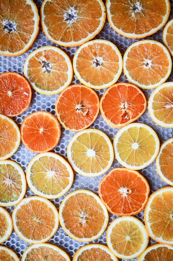 Sliced oranges on a wire rack are about to go into the oven to dehydrate. 