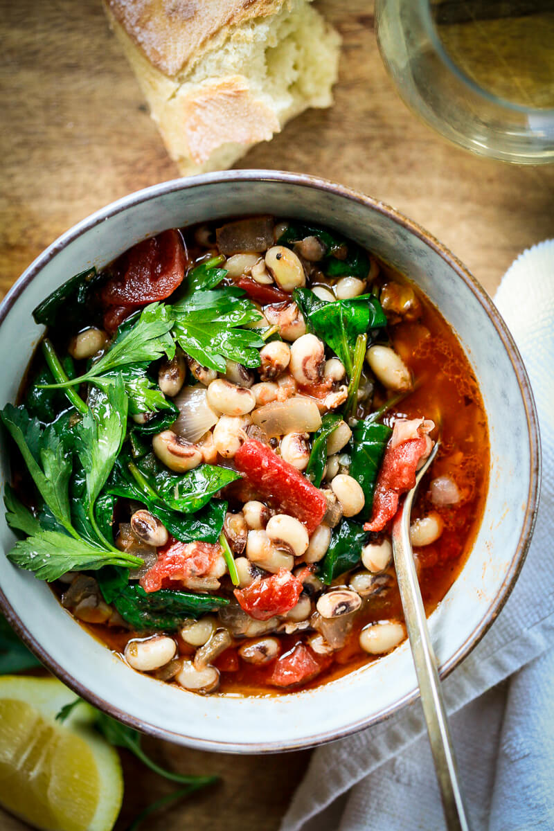 A bowl of vegetarian, vegan black eyed peas with spinach and tomatoes.