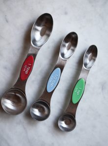 A teaspoon, half teaspoon, and tablespoon sit on a counter to show the size difference.