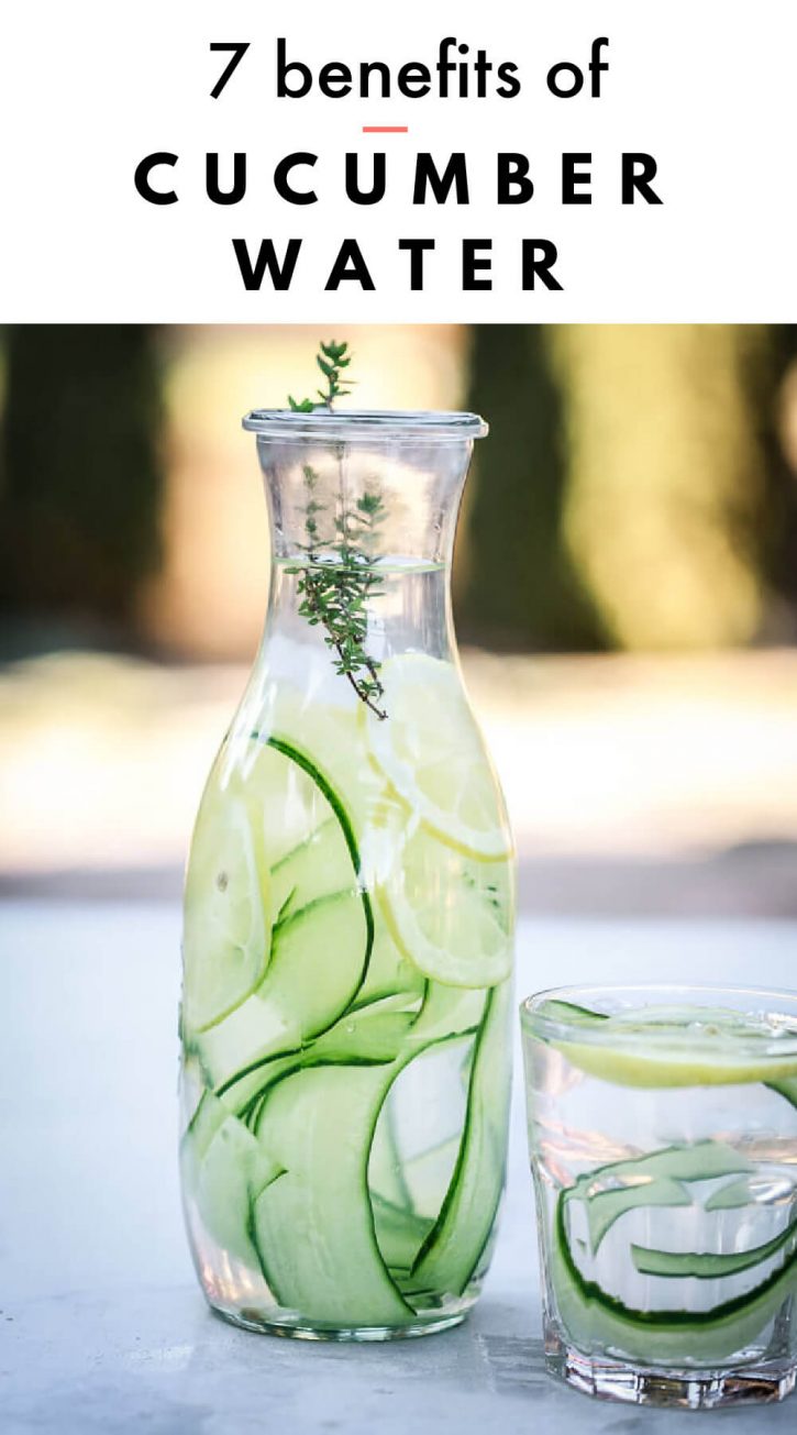 Beautiful photo of a glass carafe filled with cucumber water outside. Text overlay reads, "7 benefits of cucumber water." 
