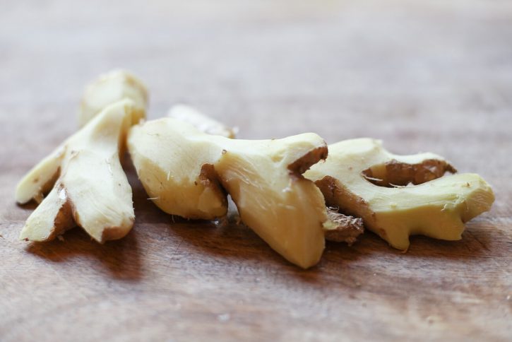A close up photo of peeled ginger root on a cutting board. 