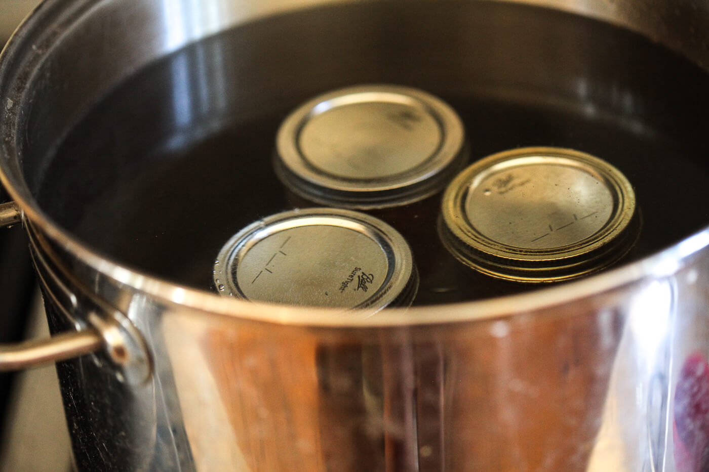 Ball canning jars in a large pot of water.