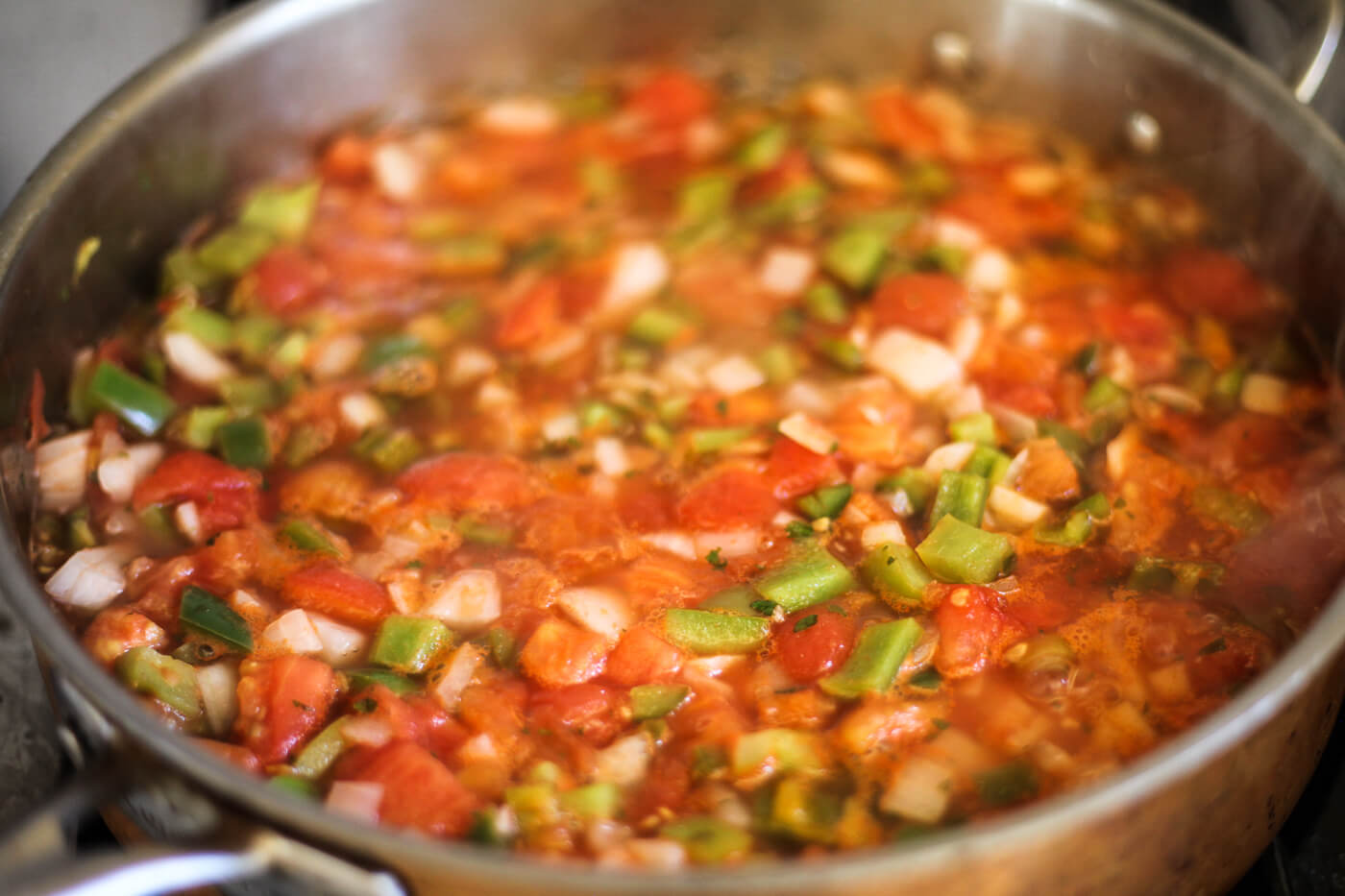 A salsa recipe for canning simmers on the stove.