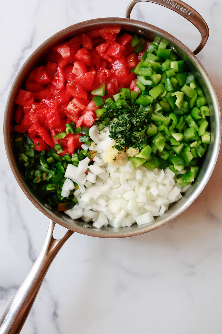 How to make salsa for canning. The ingredients for homemade chunky Mexican salsa are seen in a large stainless steel saucepan. 