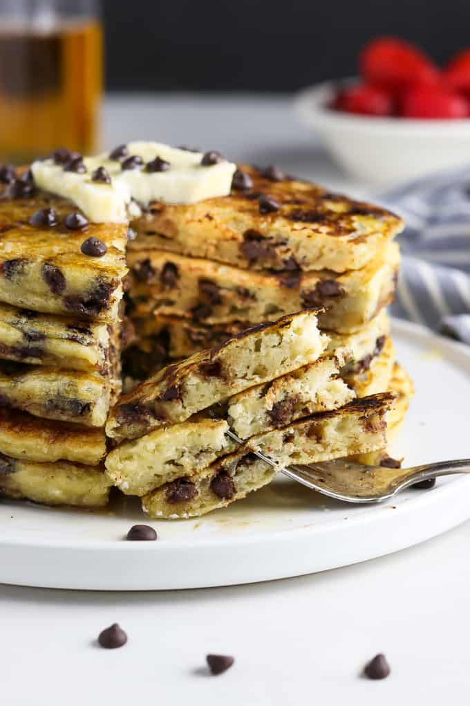 A stack of chocolate chip pancakes on a white plate. 