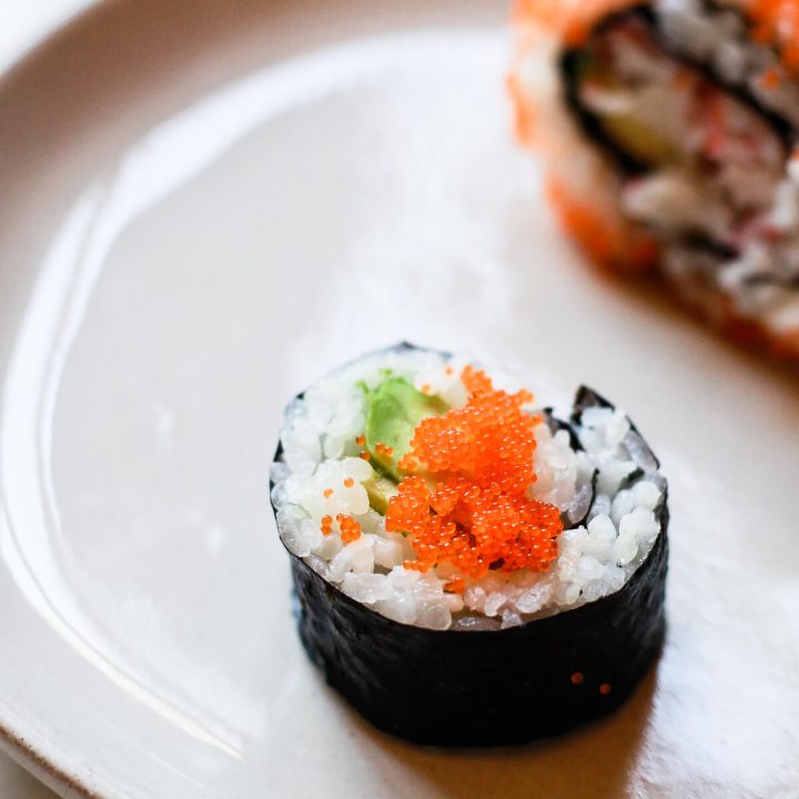 Two sushi rolls topped with masago.