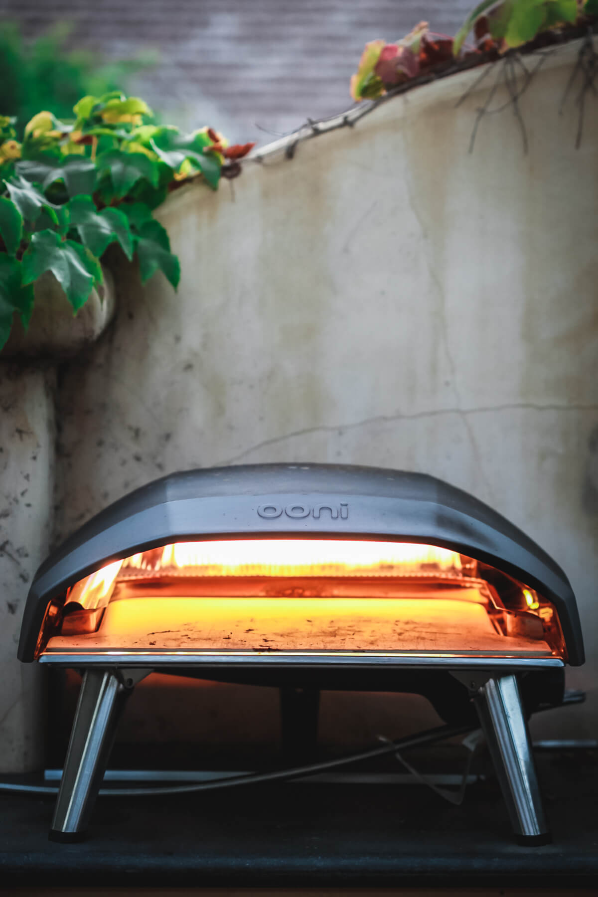 An Ooni Koda 16 pizza oven sits on an outdoor kitchen counter. 