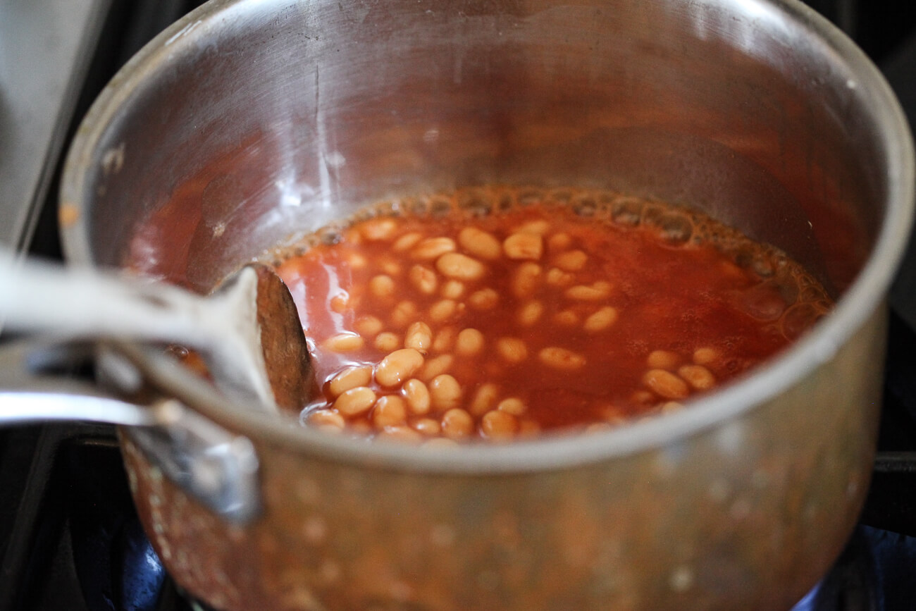 Heinz British beans simmer gently in a small saucepan on the stove.