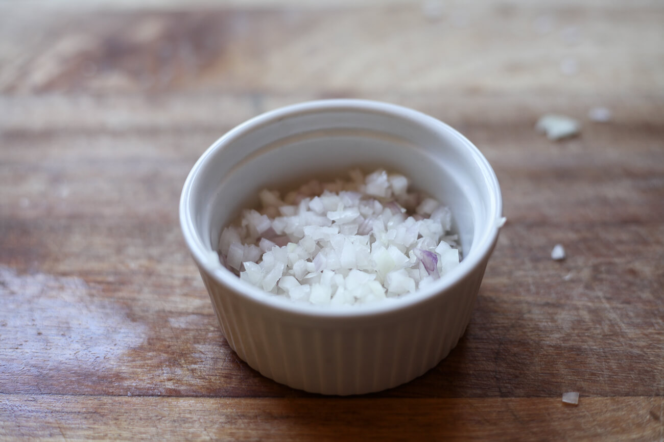 A white rameken filled with minced shallots