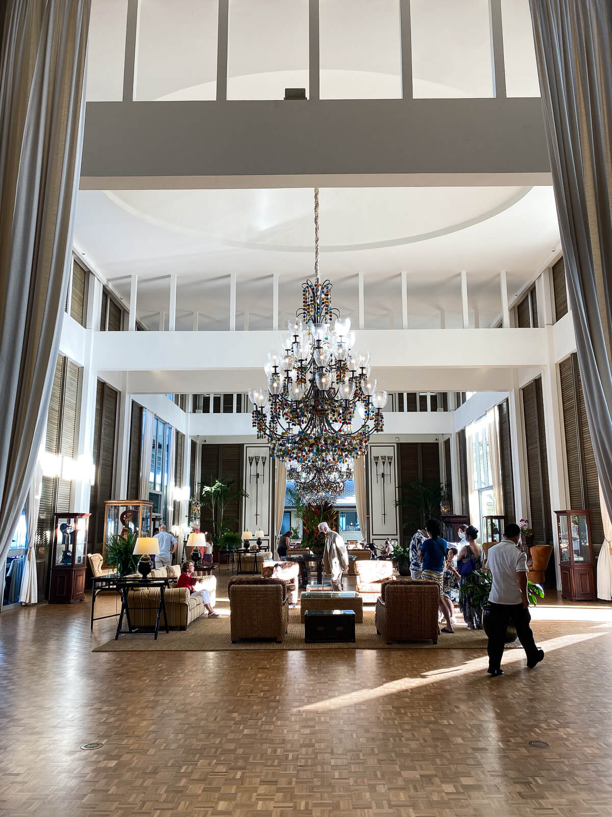 The grand lobby at the Kahala hotel with large chandelier and high ceilings. 